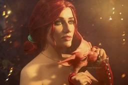 Una modelo muestra un cosplay de Triss de The Witcher 3: Wild Hunt con un atuendo para un baile de máscaras