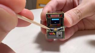 Un artesano popular creó una diminuta máquina recreativa controlada por un palillo de dientes